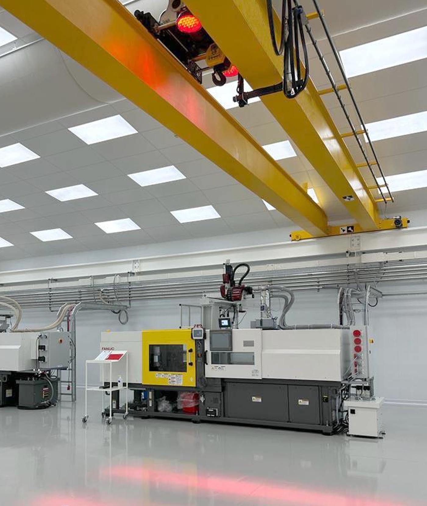 Overhead crane hazard warning light projected onto a factory floor