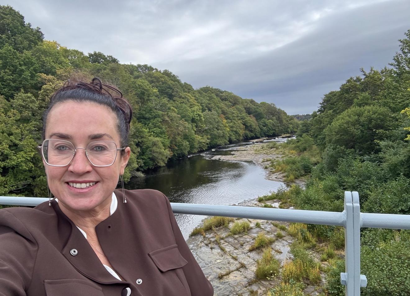 Amanda Gardiner on the restored Whorlton Bridge, with the River Tees and wooded banks behind her